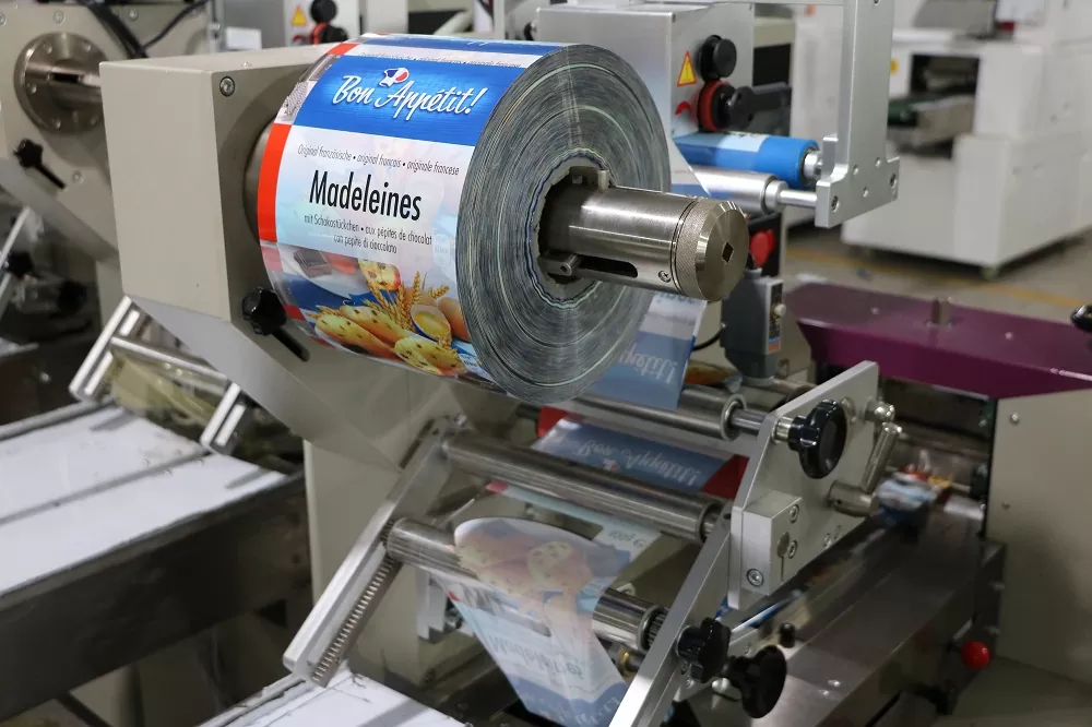 Cách thức hoạt động của thiết bị: Băng tải hoạt động: Là chìa khóa cơ khí trong bộ phận của thiết được làm bằng thép không gỉ, phù hợp với thực phẩm QS. Bảng tải truyền mọi hoạt động từ khâu đóng gói xúc xích đến với nhân công để sắp xếp phù hợp bỏ vào thùng Thiết bị làm phồng túi: Tự động cuộn phim hình thành hình dạng túi, linh hoạt trong sản xuất với các dạng kích thước khác nhau và thuận tiện cho cơ sở là không cần điều chỉnh quá nhiều lần cho các sản phẩm khác nhau nên tiết kiệm được thời gian Màn hình cảm ứng: Được cài đặt với nhiều ngôn ngữ khác nhau nên có thể điều chỉnh sao cho phù hợp môi trường làm việc của bạn. Màn hình cảm ứng với kích thước lớn nên dễ dàng cài đặt, hiện thị rõ các thông số và có thể dừng mọi hoạt động chỉ với một nút bấm Dao cắt và niêm phong sản phẩm: Bộ phận dao hoạt động liên tục để cắt sản phẩm sao cho đúng vị trí Định hình vị trí: Sử dụng bên ngoài phim vị trí cấu trúc, bao bì phim cài đặt là đơn giản hơn và một cách nhanh chóng hơn cho việc sản xuất