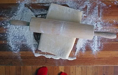 Pain Au Chocolat – được mệnh danh người anh em của bánh Croissant Pain au chocolat hay còn được gọi là bánh mì socola – 1 trong 7 món ngon Paris dành cho người hảo ngọt. Không ai biết nguồn gốc cụ thể của chiếc bánh này, nhưng tất cả đều chắc chắn rằng việc cho chocolate vào công thức làm bánh này là “một tai nạn tuyệt vời”. Lớp vỏ giòn xốp thơm ngậy, lại có thêm hương vị socola đắng đắng ngọt ngọt nồng nàn bên trong, khiến ai đã nếm một lần đều nhớ mãi không quên. Có khả năng nói người Pháp chính là bậc thầy trong việc biến những món ăn tưởng chừng giản đơn trở thành hấp dẫn và xinh xắn hơn rất nhiều. Và bánh Pain Au Chocolat chính là một trong những số đó. Bánh được làm từ bột mì, sữa tươi, bơ, trứng, ngặt nghèo lớp phủ chocolate vô cùng đơn giản tuy nhiên lại đẹp mắt và mang lại hương vị ngọt ngào khó cưỡng. nếu như là một người hảo ngọt thì bạn không nên bỏ qua loại bánh này đâu. Nguyên liệu làm bánh: Phần vỏ bánh: 60 gram bơ nhạt, để ở nhiệt độ phòng 500 gram bột mì đa dụng 50 gram đường 2 thìa cà phê muối 9.3 gram men instant 360ml sữa bò nguyên kem 115 gram socola đắng vừa, thái nhỏ Đường bột trang trí (tùy chọn) Phần bơ: 345 gram bơ nhạt, để ở nhiệt độ phòng 16 gram bột mì đa dụng Phần trứng phết lên Pain au Chocolat: 1 quả trứng 30ml sữa bò nguyên kem Cách làm gồm các bước sau đây: Bước 1: Chia 60 gram bơ ra làm 4 phần, cho vào tô cùng bột mì, đường, muối và men. Trộn đều bằng máy trộn ở tốc độ trung bình thấp. Đổ từ từ 360ml sữa vào hỗn hợp. Khi đã cho hết sữa vào, tăng tốc độ đánh lên trung bình hoặc nhồi bằng tay trong tối thiểu 5 phút. Khi quan sát thấy bột gần như tách khỏi thành tô và đàn hồi lại khi nhấn ngón tay vào là thành công. Bước 2: Phủ bột đều lên tay và mặt khay, lấy bột ra khỏi tô và nhồi thành hình tròn. Sau đó, bọc lại bằng màng bọc thực phẩm hoặc giấy bạc. Cho vào ngăn mát tủ lạnh và để bột nghỉ trong 30 phút. Bước 3: Lấy bột ra khỏi tủ lạnh và dàn phẳng bột bằng tay, sao cho phần bột thành hình tứ giác có kích thước 25x35cm. Đừng lo lắng nếu lúc này bột vẫn chưa lạnh hẳn và có cảm giác như nhào đất nặn mềm. Bước 4: Bọc lại màng bọc thực phẩm hoặc giấy bạc lên phần bột đã dàn phẳng, chú ý giữ nguyên kích thước. Để bột nghỉ trong ngăn mát tủ lạnh ít nhất 4 tiếng hoặc để qua đêm. Bước 5: Đánh đều bơ cùng bột mì đến khi hỗn hợp đều và mịn. Bỏ lên khay nướng bằng silicon để có thể dễ dàng tách ra khi cần thiết. Dùng thìa hoặc cây vét bột dàn phẳng hỗn hợp ra thành hình tứ giác kích thước 17x25cm. Cho khay bơ vào tủ lạnh trong 30 phút. Bước 6: Mang phần bột ở bước 4 và phần bơ ở bước 5 ra ngoài, để lên mặt bếp đã được phủ bột lên. Đặt phần bơ lên trên chính giữa phần bột, phủ 2 cạnh bột thừa ra lên trên và nắn để bọc hoàn toàn phần bơ vào bên trong. Sau đó, cán bột thành tứ giác kích thước 25x50cm. Khi cán, bột sẽ rất lạnh và khó thành hình tứ giác, hãy kiên nhẫn đến khi bột thành hình chính xác. Sau đó, dùng mắt chia bột thành 3 phần đều nhau rồi gấp lại. Đây là lần thứ nhất. Bước 7: Nếu lúc này bột trở nên quá ấm, cho vào khay và bọc lại bằng màng bọc thực phẩm và để bột nghỉ 30 phút trong ngăn mát tủ lạnh. Bước 8: Lấy bột ra khỏi tủ lạnh, cán bột lại thành kích thước 25x50cm như ban đầu. Sau đó, dùng mắt chia bột thành 3 phần đều nhau rồi gấp lại. Đây là lần thứ hai. Cho bột vào khay và bọc lại bằng màng bọc thực phẩm và để bột nghỉ 30 phút trong ngăn mát tủ lạnh. Bước 9: Lấy bột ra khỏi tủ lạnh, cán bột lại thành kích thước 25x50cm như ban đầu. Sau đó, dùng mắt chia bột thành 3 phần đều nhau rồi gấp lại. Bước 10: Đặt phần bột đang gấp lại lên khay nướng silicon, bọc kín lại bằng màng bọc thực phẩm. Để bột nghỉ trong ngăn mát tủ lạnh ít nhất 4 tiếng hoặc để qua đêm. Bước 11: Lấy bột ra khỏi tủ lạnh, cán thành hình tứ giác kích thước 20x50cm. Cắt dọc thành 2 phần đều nhau kích thước 20x25cm. Tiếp tục cắt ngang thành 3 phần đều nhau, để có 8 phần bột kích thước 10x12cm. Bước 12: Cắt đôi tiếp để có 16 phần bột hình tứ giác kích thước 5x12cm. Cán bột nhẹ nhàng để kéo dài ra thành 5x20cm. Cho socola vụn vào giữa, cuộn chặt và hướng phần mép bột xuống dưới. Tiếp tục đến khi hết 16 cái bánh socola. Cho bánh vào 2 khay nướng lót giấy nến, phủ màng bọc thực phẩm lên trên và để bột nghỉ khoảng 1 tiếng ở nhiệt độ thường. Sau đó, để vào ngăn mát tủ lạnh trong ít nhất 1 tiếng, tối đa 12 tiếng. Bước 13: Làm nóng lò trước ở 204°C. Trộn đều phần trứng phủ. Lấy bánh ra khỏi tủ lạnh, quét nhẹ phần trứng lên trên và cho vào lò nướng. Bước 14: Nướng khoảng 20 phút đến khi bánh vàng ruộm. Sau khoảng 10 phút đầu tiên, mở lò ra và xoay ngược khay nướng bánh lại, nếu quan sát thấy bánh chín quá nhanh, hạ nhiệt độ xuống 190°C. Bước 15: Sau khi lấy bánh ra khỏi lò, để trên giá vài phút để bánh nguội bớt. Bánh ngon nhất khi ăn luôn trong ngày. Tuy nhiên, có thể để bánh 2-3 ngày ở ngoài hoặc 1 tuần trong ngăn mát tủ lạnh. Chúc các bạn hoàn thành món bánh này để có thể tặng cho bạn bè hoặc thay đổi món ăn vặt cho gia đình bạn. Bạn có thể theo dõi chúng tôi để có thể làm ra nhiều món ăn khác nhau nhé! Đối với các cơ sở - doanh nghiệp quan tâm đến các loại máy đóng gói có thể liên lạc với Máy đóng gói An Thành - chúng tôi để được tư vấn, hỗ trợ để tìm cho bạn chiếc máy phù hợp sản phẩm mà bạn đang đóng gói. CÔNG TY TNHH SẢN XUẤT – THƯƠNG MẠI – DỊCH VỤ – AN THÀNH Địa chỉ: 47/80 Ao Đôi, Khu Phố 10, Phường Bình Trị Đông A, Quận Bình Tân, TP.HCM Email: anthanhsale01@gmail.com Hotline (zalo) : 0903103922 – 0906312325 Website: https://www.packvn.com/ – https://maydonggoi.vip/ Facebook: https://www.facebook.com/maydonggoianthanh Pinterest: https://www.pinterest.com/donggoianthanh/_saved/ Instagram: https://www.instagram.com/maydonggoianthanh/ Twitter:https://twitter.com/donggoianthanh Linkedin: https://www.linkedin.com/in/may-dong-goi-bao-bi-an-thanh/ Youtube: Máy đóng gói An Thành – YouTube.